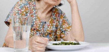 Dame âgée qui prend un repas